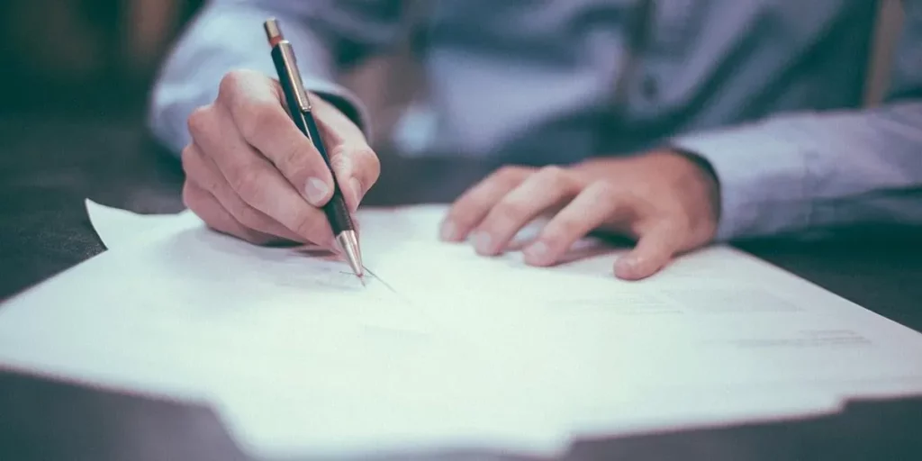 Signature d'un contrat de prévoyance obsèques avec un stylo sur un document.